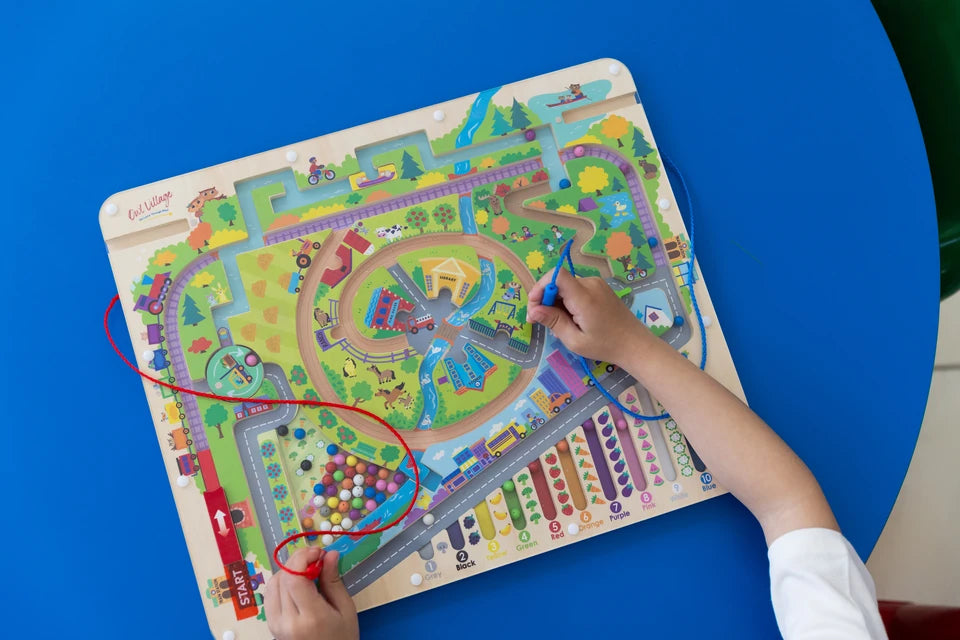 A child guiding the magnetic pen through the village paths