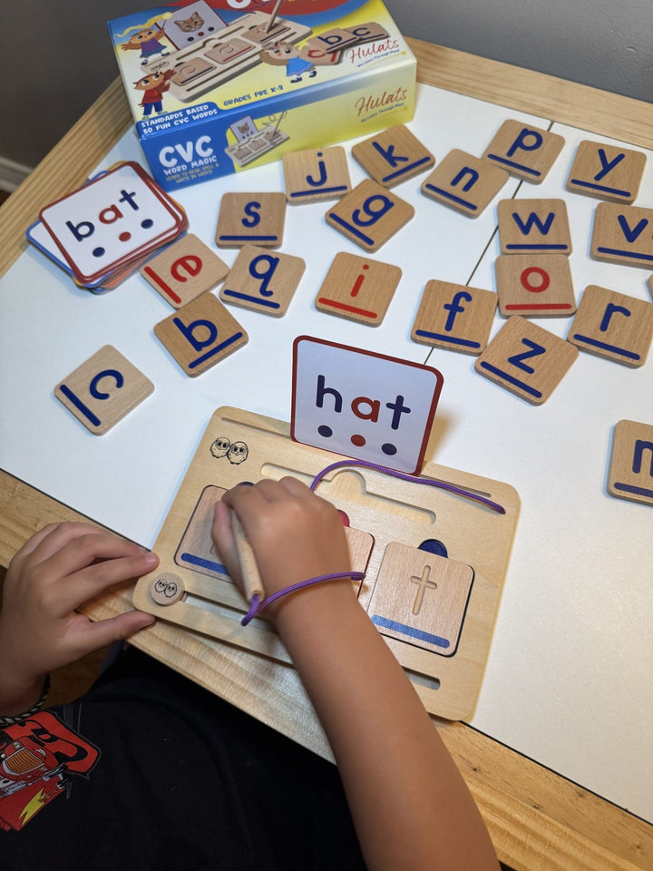 Hands exploring a CVC word card and letter tiles